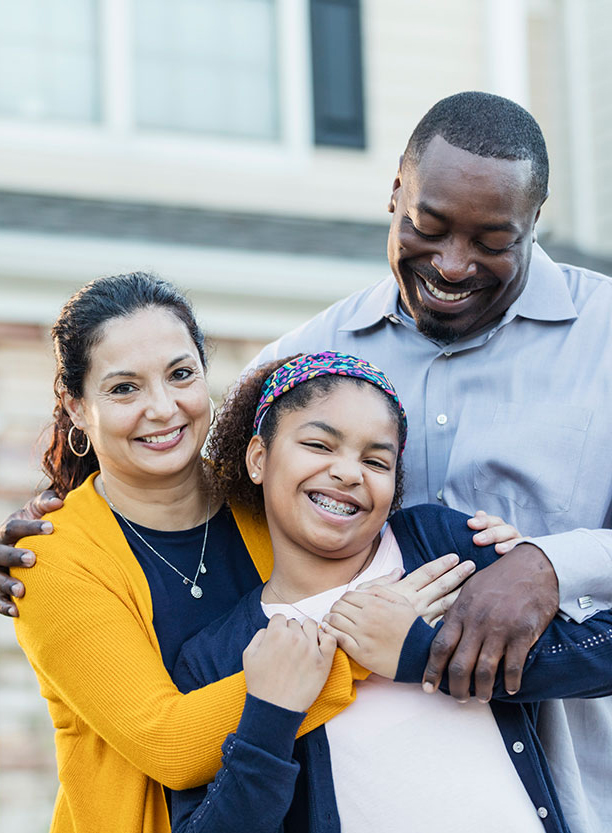 A happy family standing in front of their home