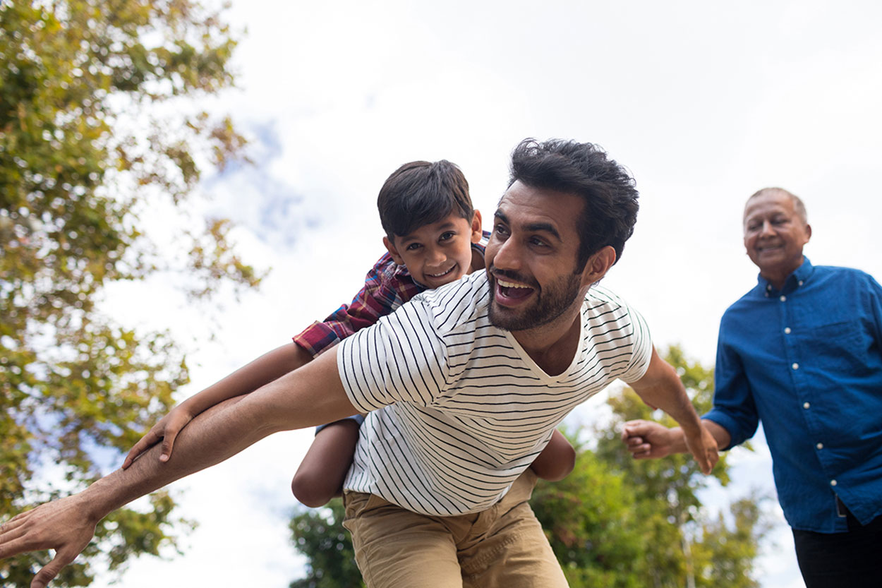 A father holding his son on his back enjoying life