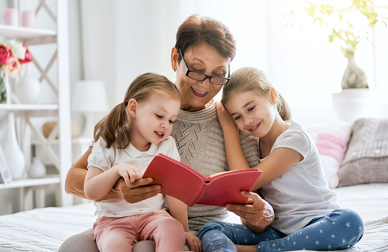 A grandmother reading a story to two young children