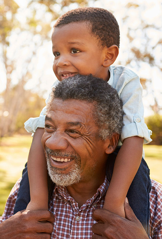 A older man caring a young child on his shoulders