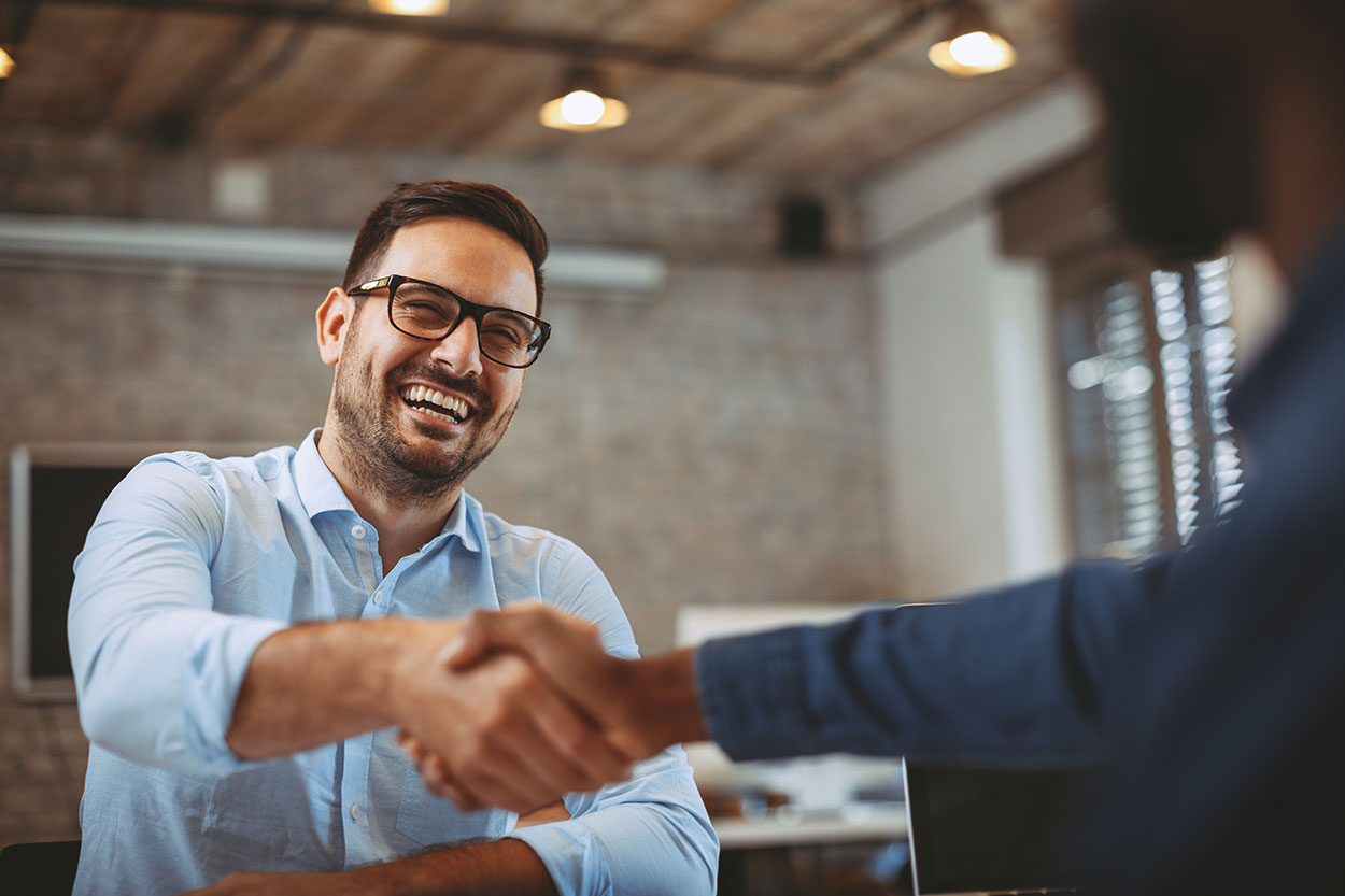 A man with a smile shaking hands